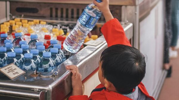 Ребенок достает бутылку с водой, иллюстративное фото - Sputnik Узбекистан