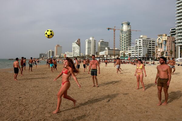 В Тель-Авиве люди играют в футбол на пляже после отмены властями Израиля масочного режима во время прогулок. - Sputnik Узбекистан