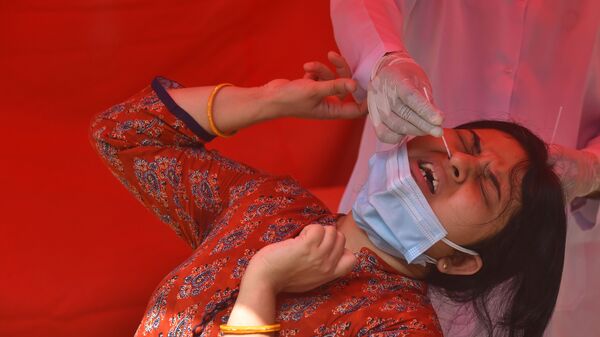 Женщина проходит тестирование на COVID-19 в центре тестирования в Дели, Индия - Sputnik Ўзбекистон