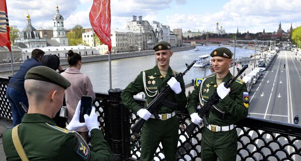 Российские военнослужащие позируют фотографу, стоя на мосту в Москве. - Sputnik Узбекистан