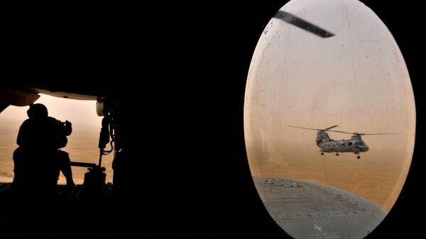 Американский солдат (слева) сидит в задней части вертолета морской пехоты Чинук - Sputnik Узбекистан