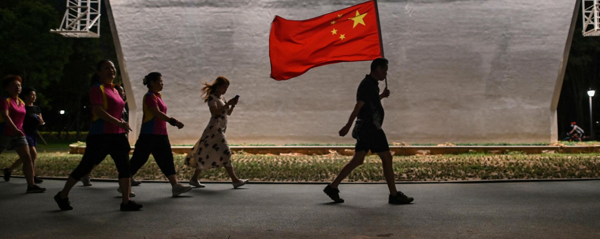 Мужчина с флагом Китая идет по парку в Ухане - Sputnik Узбекистан, 1920, 13.05.2021