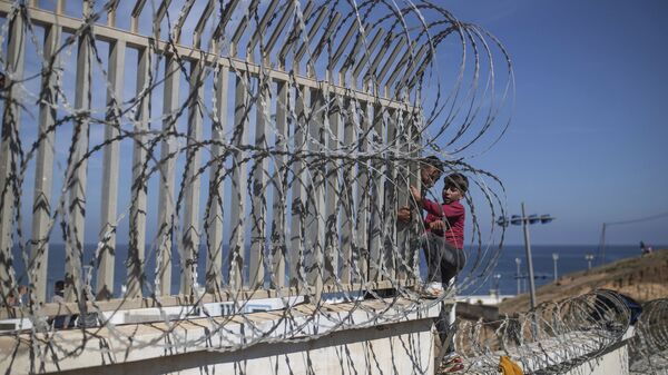 Мигранты перелезают через забор на границе Марокко и Испании, недалеко от испанского анклава Сеута - Sputnik Узбекистан