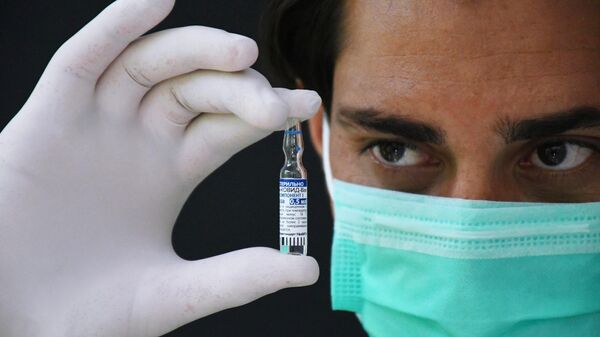 Медицинский работник держит в руках ампулу с российским препаратом от коронавирусной инфекции Гам-Ковид-Вак (Спутник V) - Sputnik Узбекистан