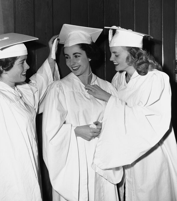 Одна из величайших звезд кино Элизабет Тейлор болтает с подругами незадолго до того, как они получили дипломы об окончании средней школы университета в Лос-Анджелесе, 26 января 1950 года. - Sputnik Узбекистан