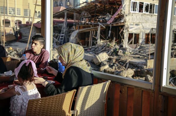 Люди на территории разрушенного дома в секторе Газа.  - Sputnik Узбекистан