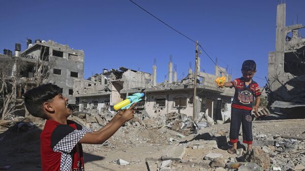 Палестинские дети играют у разрушенных домов в Газе  - Sputnik Ўзбекистон