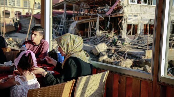 Люди на территории разрушенного дома в секторе Газа - Sputnik Узбекистан
