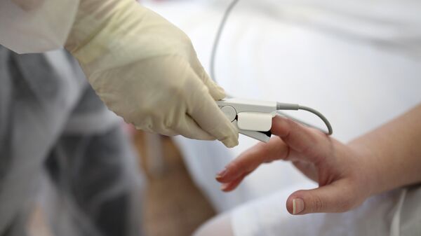 Медицинский работник измеряет сатурацию у пациентки с COVID-19 - Sputnik Ўзбекистон