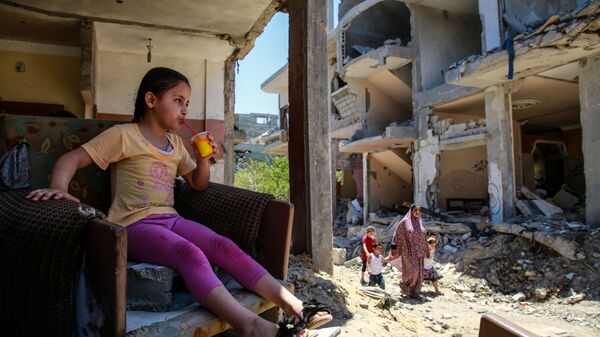 Devochka pyet sok v razrushennom dome na severo-vostoke sektora Gaza v gorode Beyt-Xanun - Sputnik O‘zbekiston
