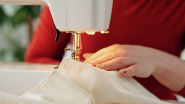 Женщина работает за швейной машинкой, иллюстративное фото - Sputnik Узбекистан