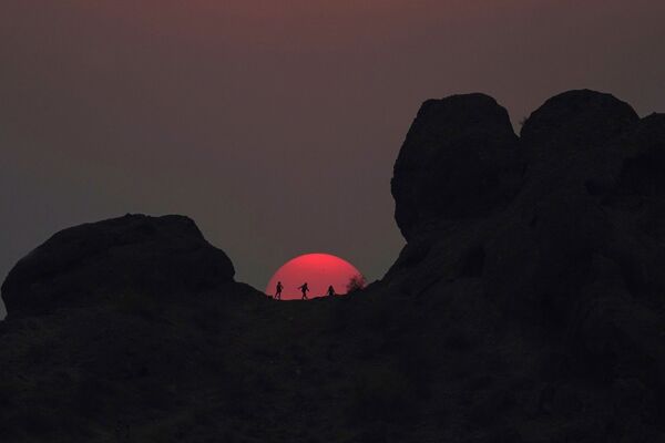 Путешественники смотрят на закат в парке Папаго в Финиксе, штат Аризона. - Sputnik Узбекистан