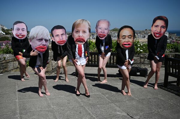 Экоактивисты Extinction Rebellion позируют с лицами лидеров G7 в Сент-Айвсе во время саммита &quot;Большой семерки&quot;. - Sputnik Узбекистан