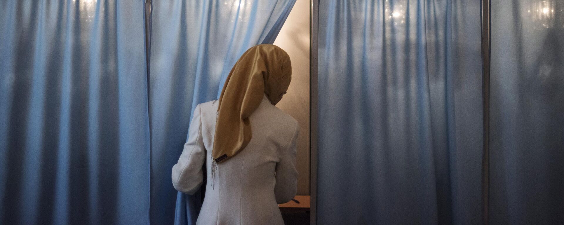 Женщина голосует на избирательном участке во время выборов президента Узбекистана. Архивное фото - Sputnik Узбекистан, 1920, 21.06.2021