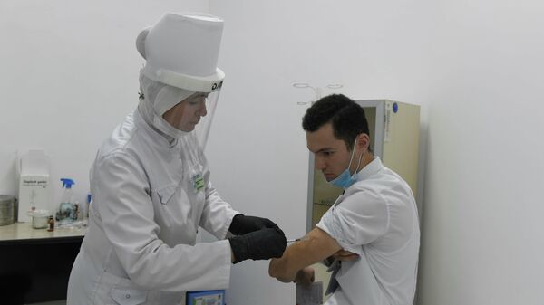 Пациент на пункте вакцинации делает прививку от коронавируса - Sputnik Узбекистан