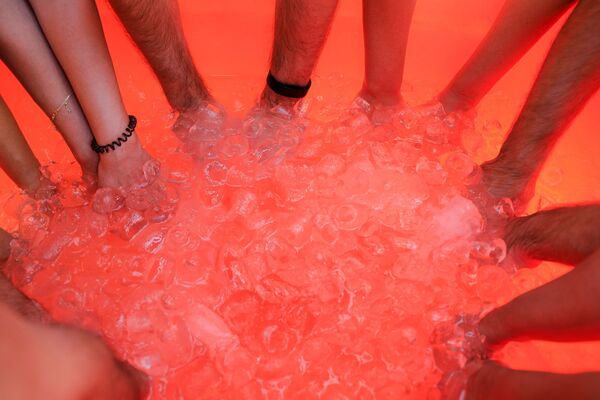Люди коллективно опускают руки в ванну со льдом. - Sputnik Узбекистан