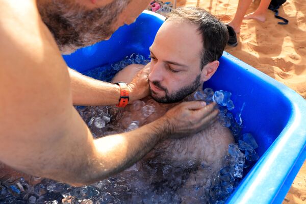 Мужчина лежит в ванне со льдом во время сеанса терапии. - Sputnik Узбекистан