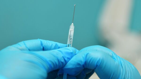 Медик готовит шприц с вакциной - Sputnik Узбекистан