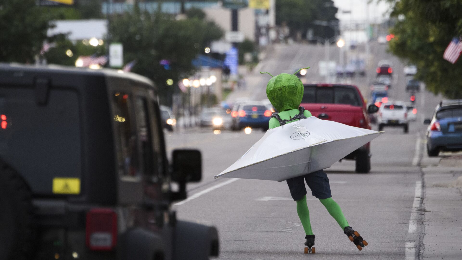 Человек в костюме инопланетянина в летающей тарелке катается на роликовых коньках по улице во время фестиваля НЛО в Розуэлле, штат Нью-Мексико, США - Sputnik Ўзбекистон, 1920, 26.10.2021