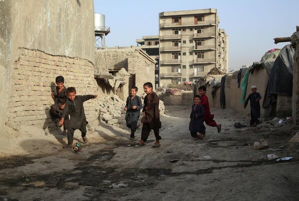 Дети играют в футбол во временном лагере для пострадавших в результате боевых действий на одной из улиц Кабула. - Sputnik Узбекистан