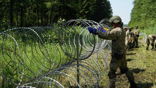 Солдаты литовской армии устанавливают забор из колючей проволоки на границе с Беларусью в городе Друскининкай - Sputnik Узбекистан