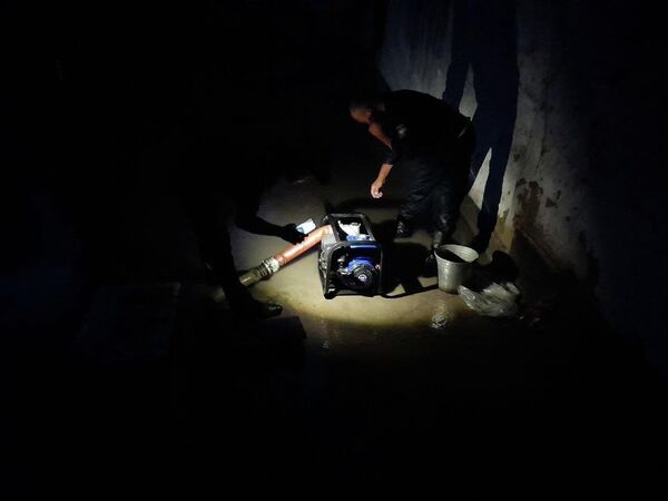 Они откачивают воду, скопившуюся в домах жителей в результате наводнений, вызванных ливнями и градом. - Sputnik Узбекистан