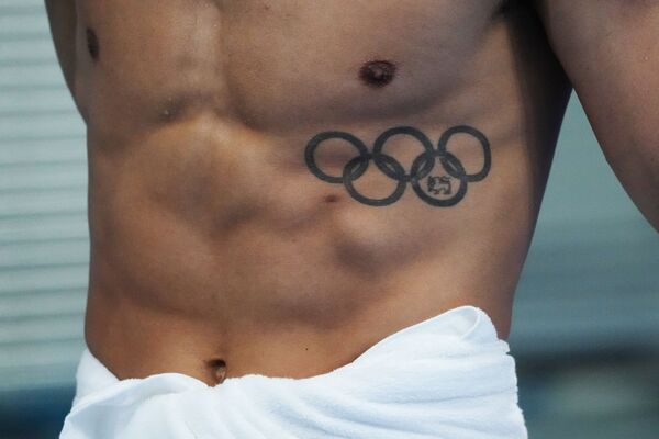 Пловец гуляет по террасе у бассейна перед соревнованиями в Аквацентре Токио на летних Олимпийских играх 2020-го. - Sputnik Узбекистан