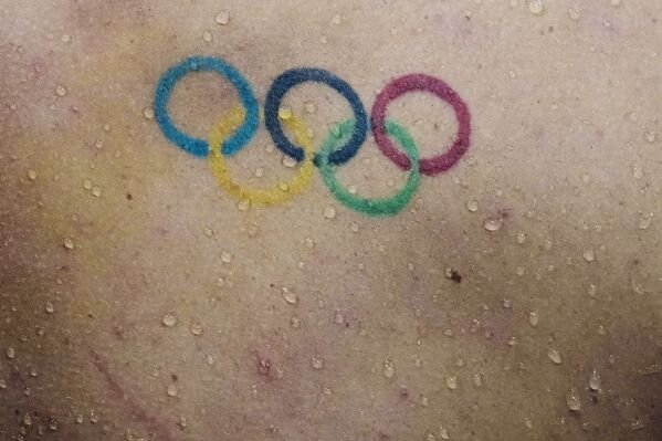 Капли воды падают на спину с татуировкой олимпийских колец пловца Таунли Хааса из США. - Sputnik Узбекистан