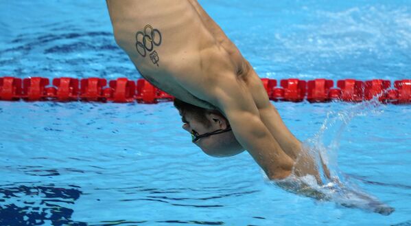 Пловец с олимпийской татуировкой во время тренировки на летних Олимпийских играх Токио-2020. - Sputnik Узбекистан