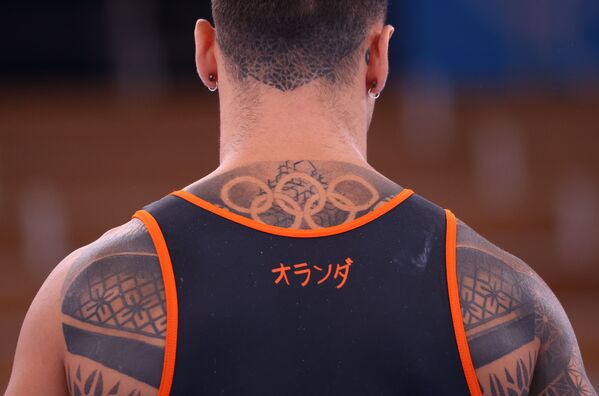 Татуировка в виде олимпийских колец на спине спортсмена из Нидерландов. - Sputnik Узбекистан