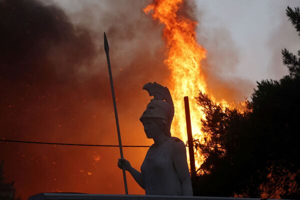 Статуя богини Афины во время пожара в пригороде Варибоби к северу от Афин. - Sputnik Узбекистан