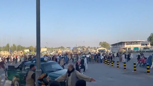 Толпы людей бегут к терминалу аэропорта Кабула после захвата президентского дворца талибами 16 августа 2021. Кадр взят из видео, опубликованного в социальных сетях. - Sputnik Узбекистан