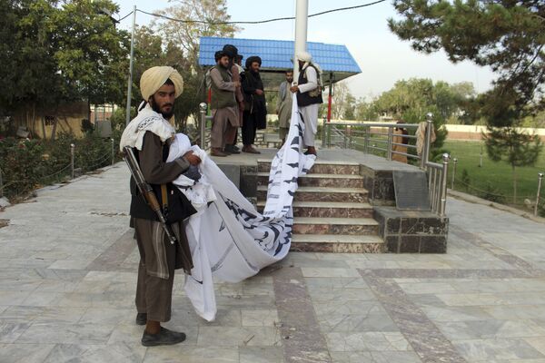 Боевики &quot;Талибана&quot;* поднимают свой флаг над резиденцией губернатора Газни на юговостоке Афганистана 15 августа 2021 г. - Sputnik Узбекистан