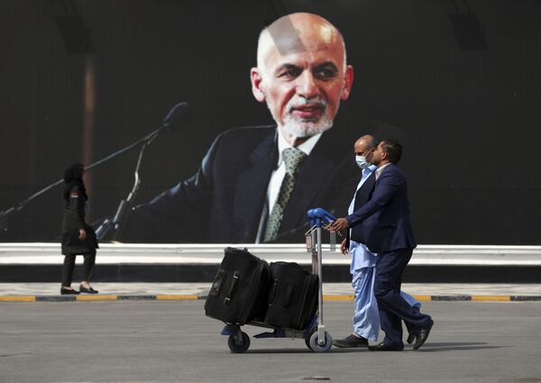 Пассажиры в Международном аэропорту Хамида Карзая в Кабуле 14 августа. После того как талибы взяли город в кольцо, остался лишь один способ выбраться из столицы и лишь один способ попасть в город для американских военных, отправленных защищать оставшихся в стране дипломатов, — по воздуху. - Sputnik Узбекистан