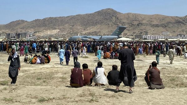 Сотни людей собрались возле транспортного самолета C-17 ВВС США на периметре международного аэропорта в Кабуле - Sputnik Узбекистан