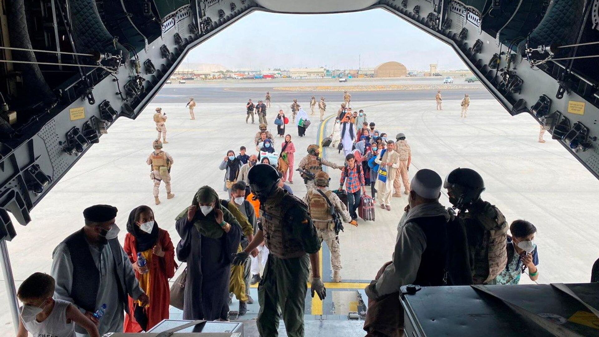 Граждане Испании и афганцы садятся в военный самолет в рамках эвакуации в международном аэропорту Хамида Карзая в Кабуле - Sputnik Узбекистан, 1920, 22.08.2021