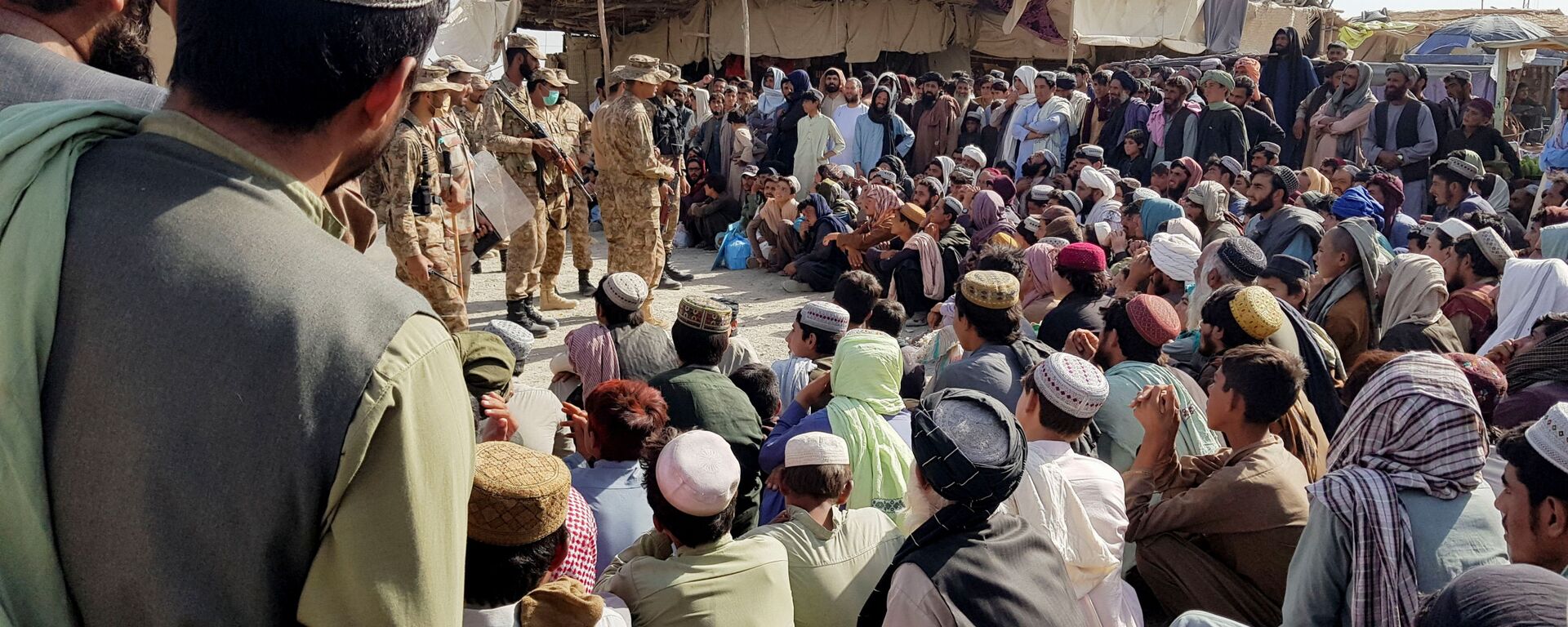 Солдаты пакистанской армии разговаривают с людьми, которые собираются пересечь пункт пропуска в пакистано-афганском пограничном городе Чаман - Sputnik Узбекистан, 1920, 23.08.2021