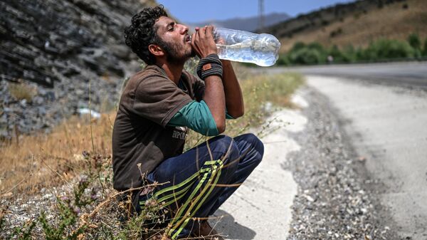 Афганский мигрант пьет воду в Татване - Sputnik Ўзбекистон