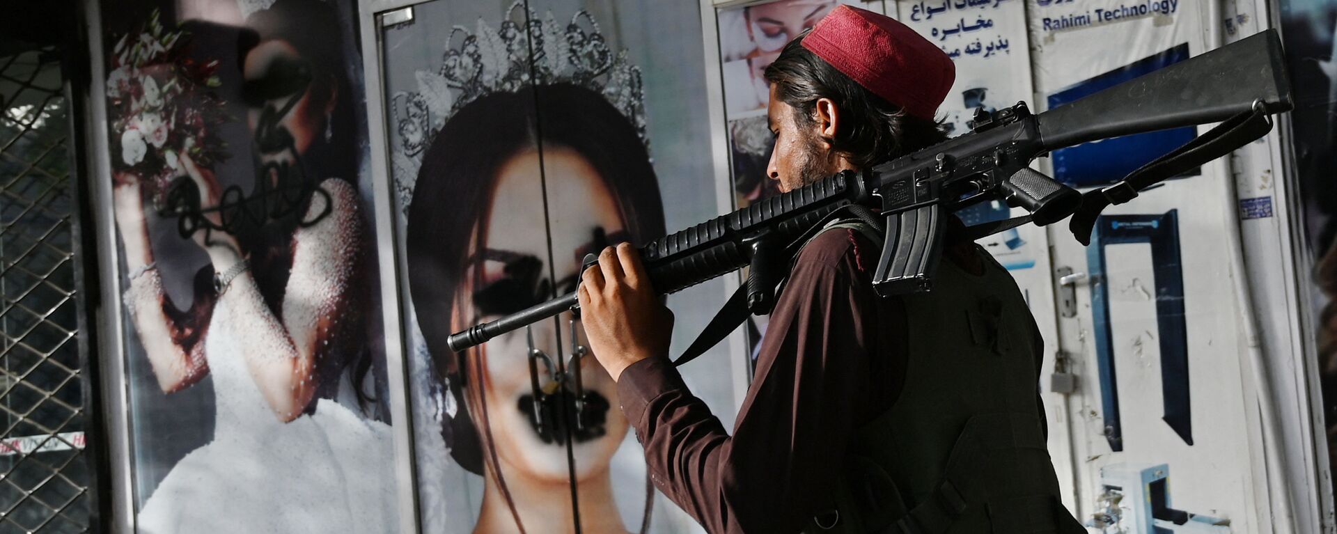 Боевик Талибана* у салона красоты с изображениями женщин, испачканных аэрозольной краской, в Шахр-э Нау в Кабуле - Sputnik Узбекистан, 1920, 26.08.2021
