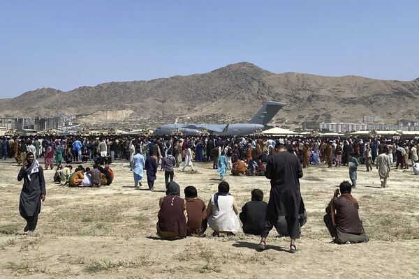 Сотни людей собрались возле самолета C-17 в аэропорту Кабула в надежде покинуть свою родину. - Sputnik Узбекистан