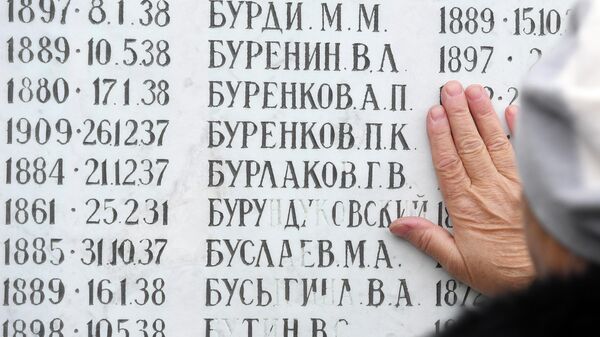 Женщина у мемориала в День памяти жертв политических репрессий - Sputnik Узбекистан