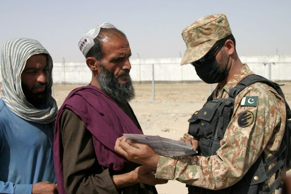 Пакистанский пограничник проверяет документы прибывших в страну афганцев. - Sputnik Узбекистан