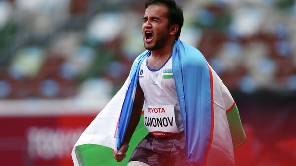 Bobirjon Omonov of Uzbekistan reacts after winning gold and setting a new Paralympic record with the flag of Uzbekistan REUTERS/Athit Perawongmetha - Sputnik O‘zbekiston
