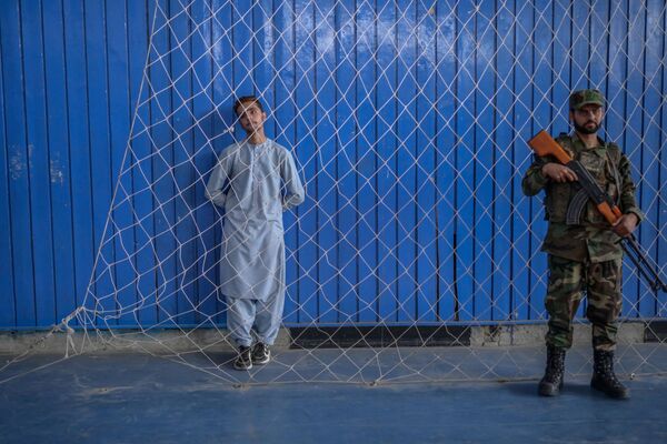 Подросток наблюдает за выступлением своих товарищей во время визита нового Директора по физическому воспитанию и спорту Башира Ахмада Рустамзая в спортзал в Кабуле 14 сентября. - Sputnik Узбекистан