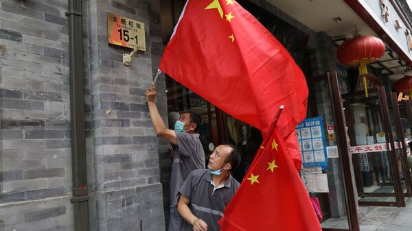 Рабочие вешают флаги перед репетицией торжеств по случаю 100-летия основания Коммунистической партии Китая - Sputnik Ўзбекистон