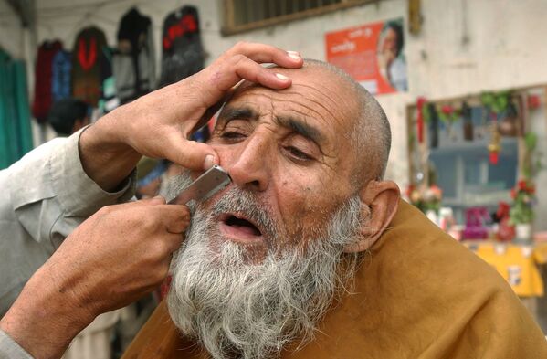 Уличный парикмахер бреет клиента в Джелалабаде, 2006 год. - Sputnik Узбекистан