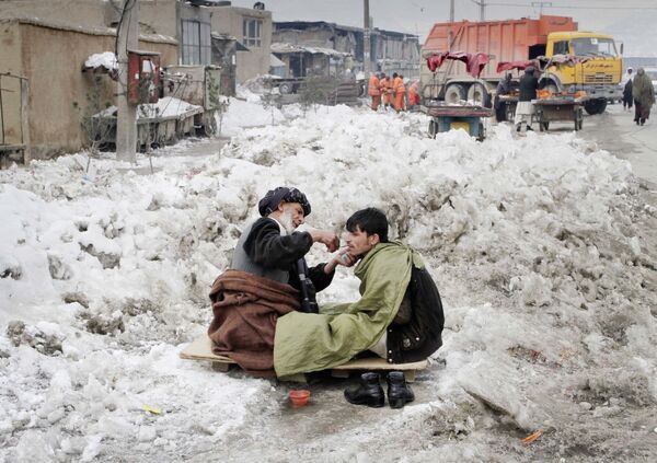 Уличный парикмахер бреет клиента во время снегопада в Кабуле, 2012 год. - Sputnik Узбекистан