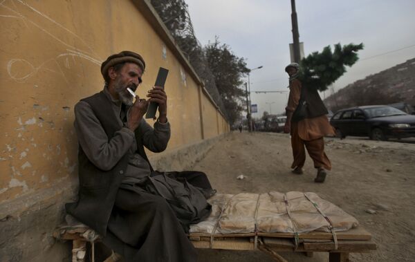 Придорожный парикмахер стрижет себе бороду, ожидая клиентов, Кабул, 2010 год. - Sputnik Узбекистан