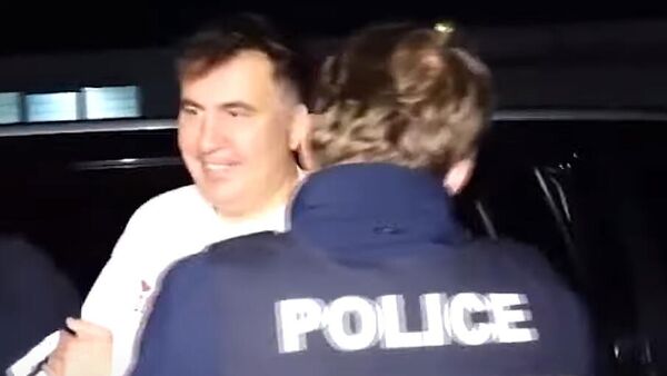 Улыбающийся Саакашвили в руках грузинской полиции - Sputnik Ўзбекистон