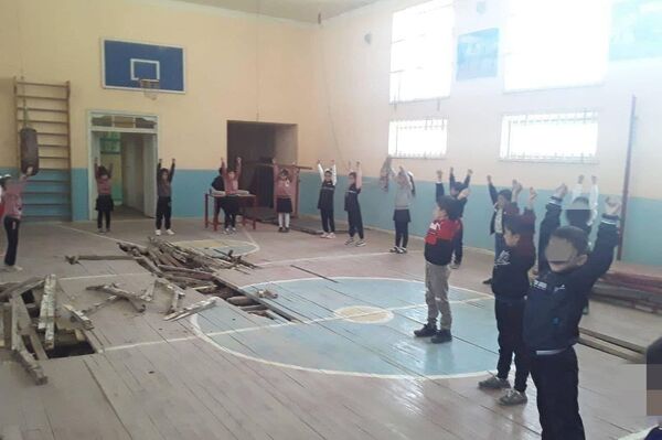 V Kashkadarye ucheniki shkoli zanimayutsya fizkulturoy na prognivshem polu sportzala - Sputnik O‘zbekiston